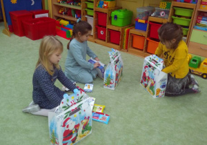 Dzieci wyjmują prezenty z paczki